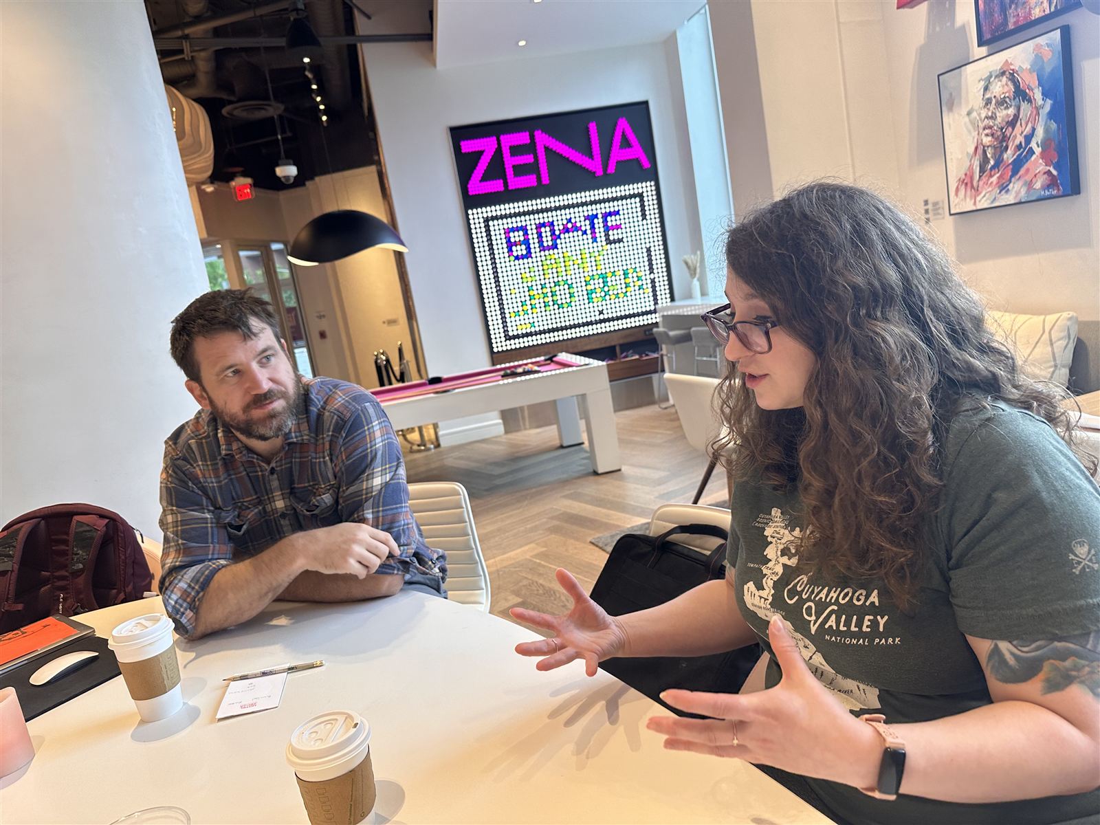 Blue Engine team members chatting at a table under a neon sign